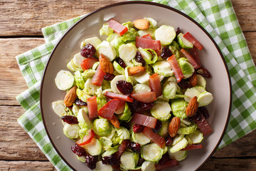 Homemade salad of sliced Brussels sprouts, cranberries, almonds and ham close-up. horizontal top view