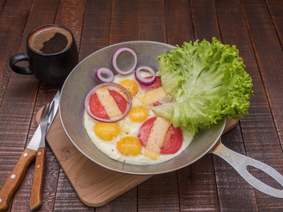 Scrambled eggs with vegetables and cheese on a wooden table.