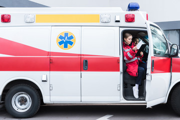 young male and female paramedics sitting in ambulance © LIGHTFIELD STUDIOS