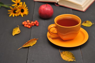Obraz na płótnie Canvas Autumn still life cup of tea, flowers and book on the table