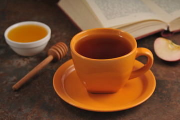 Autumn still life cup of tea, honey and book on the table