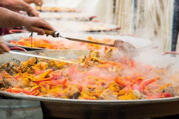 Stirring of cooking ingredients in large frying pans.The giant paella.