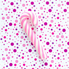 Pink caramel spiral stick on the purple dotted background