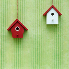 Obraz na płótnie Canvas Miniature red and white birdhouses on the green background