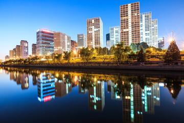 Fototapeta na wymiar Business district office buildings and water reflection in Beijing at night