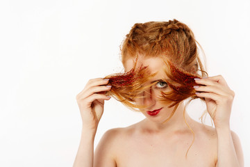 Naklejka premium Pretty girl with red hair looks like a lion posing in the studio