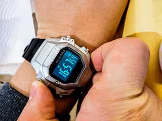 A traditional digital watch, scratched and with a background light on. This watch is twenty years old when the image was taken and still works perfectly.
