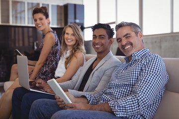 Portrait of smiling business people sitting together on sofa