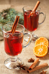 Glasses of Christmas mulled wine with spices and orange on sackcloth