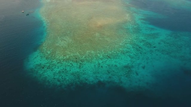 Aerial view coral reef, atoll with turquoise water in the sea.Tropical atoll, coral reef in ocean waters. 4K video. Travel concept. Aerial footage.