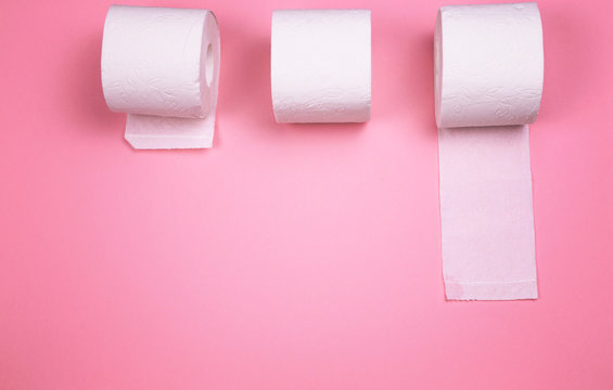 A few rolls of toilet paper on a bright colored background.