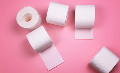 A few rolls of toilet paper on a bright colored background.