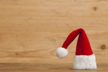 Obraz na płótnie Canvas Christmas Santa hat on a wooden background