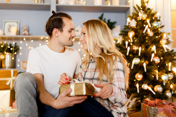 Sweet couple opening Christmas gifts
