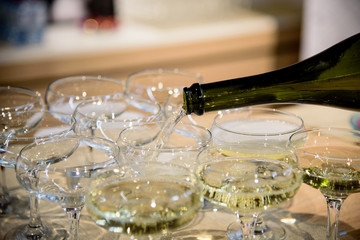 Man fills glasses of champagne in restaurant during some festive event