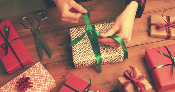 gift wrapping. woman tie a green ribbon bow