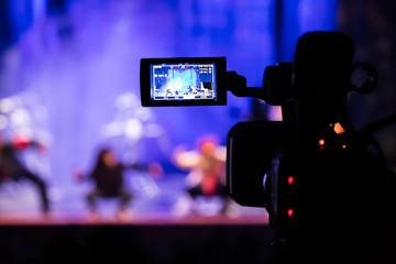 Filming the show from the auditorium. LCD viewfinder on the camcorder. Theatrical performance. The actors on stage. Out-of-focus background. The focus in the foreground.