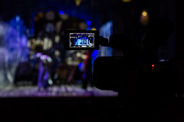 Filming the show from the auditorium. LCD viewfinder on the camcorder. Theatrical performance. The actors on stage. Out-of-focus background. The focus in the foreground.
