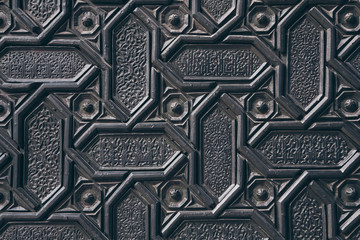 close-up shot of black wall with carved arabesque pattern