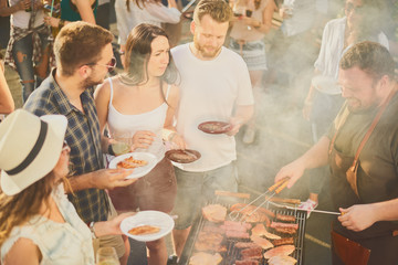 Group of people having meal at barbecue party