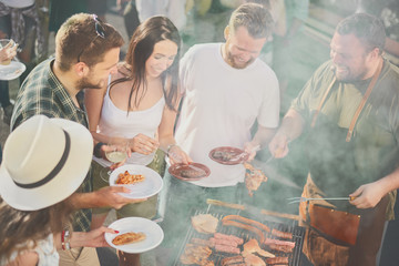 Group of people having meal at barbecue party