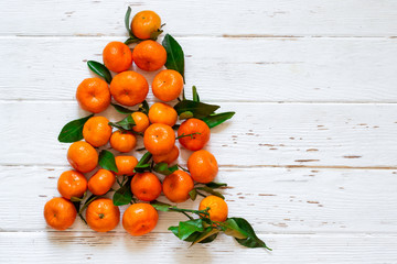 Fototapeta na wymiar Christmas New Year tree of tangerines on white wooden background