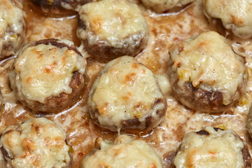 Baked champignon mushroom appetizers stuffed with parmesan cheese crust, closeup