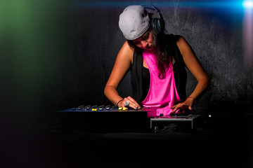 Glamorous girl deejay at work mixing sound on her console at a p