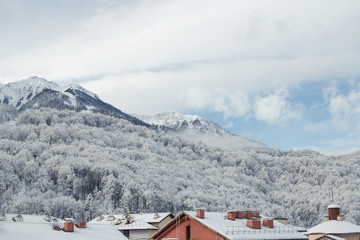snow-capped mountain, blue sky, white clouds, roofs of houses