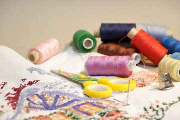 Fototapeta na wymiar embroidered pattern and threads needle scissors 