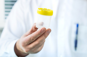 Doctor holding urine sample cup. Medical test in hospital. © terovesalainen