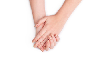 Obraz premium Closeup of hands of a young woman with manicure on nails against white background.