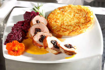 Mit Pflaumen gefülltes Schweinefilet im Schinkenmantel mit Rotkohl und Rösti auf Kürbissauce