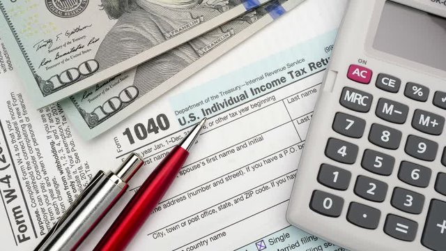 USA Tax Form 1040 and dollar bills, close up. High angle view.
