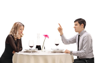 Angry guy threatening his girlfriend at a restaurant table