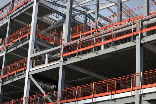 steel framed building under construction with girders and orange safety rails