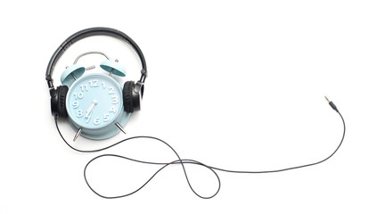 Time to rest.Alarm clock and headphone isolated over white background.