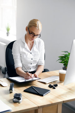 Working Woman Taking Notes In Office