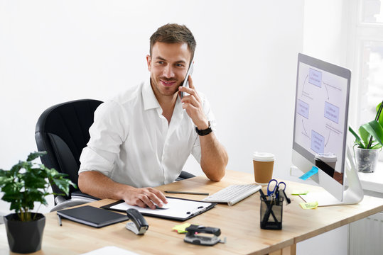 Businessman Talking On Phone At Workplace