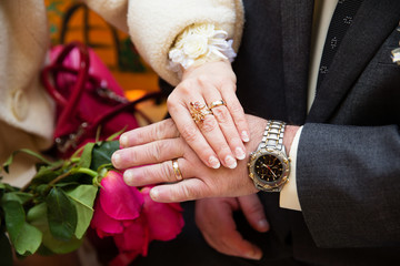 Wedding boutonniere on suit of groom and bride&rsquo;s hand 