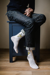 Feet in woollen socks. Man is relaxing with a cup of hot drink and warming up his feet in woollen socks. - 182967376