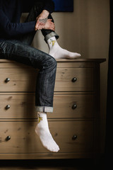 Feet in woollen socks. Man is relaxing with a cup of hot drink and warming up his feet in woollen socks. - 182967953