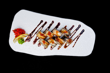 Sushi Roll with eel and salmon caviar. Top view. Isolated on a black background