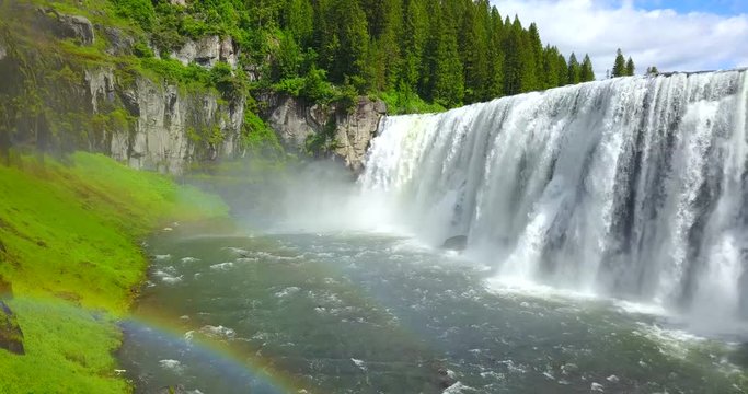Mesa Falls Idaho - Drone Aerial Approaching View Of Wide Waterfalls Surrounded By Green Pine Trees With A Rainbow