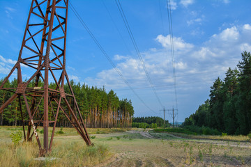 High-voltage support in the forest. Electricity pylon. High voltage line.