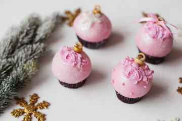 Fototapeta na wymiar Christmas decorative dessert pink chocolate and sugar mastic cupcake festive concept on white background