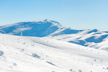 Fototapeta na wymiar Range of mountains peaks in snow. Winter landscape
