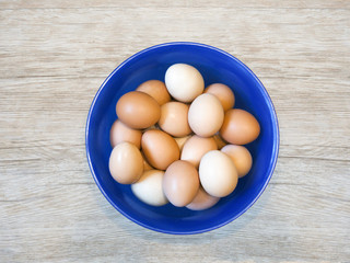 eggs in a  plastic bowl  on a wooden background