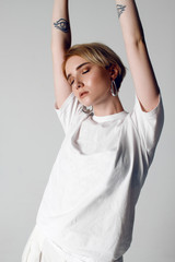 Portraits of a beautiful girl with a short hairstyle on a white background in a white T-shirt