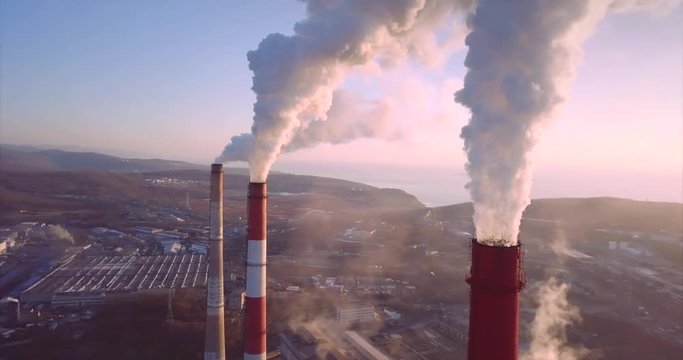 Aerial panoramic view of Central Heating and Power Plant chimneys with steam rising from them. Vladivostok, Russia. Sunrise
